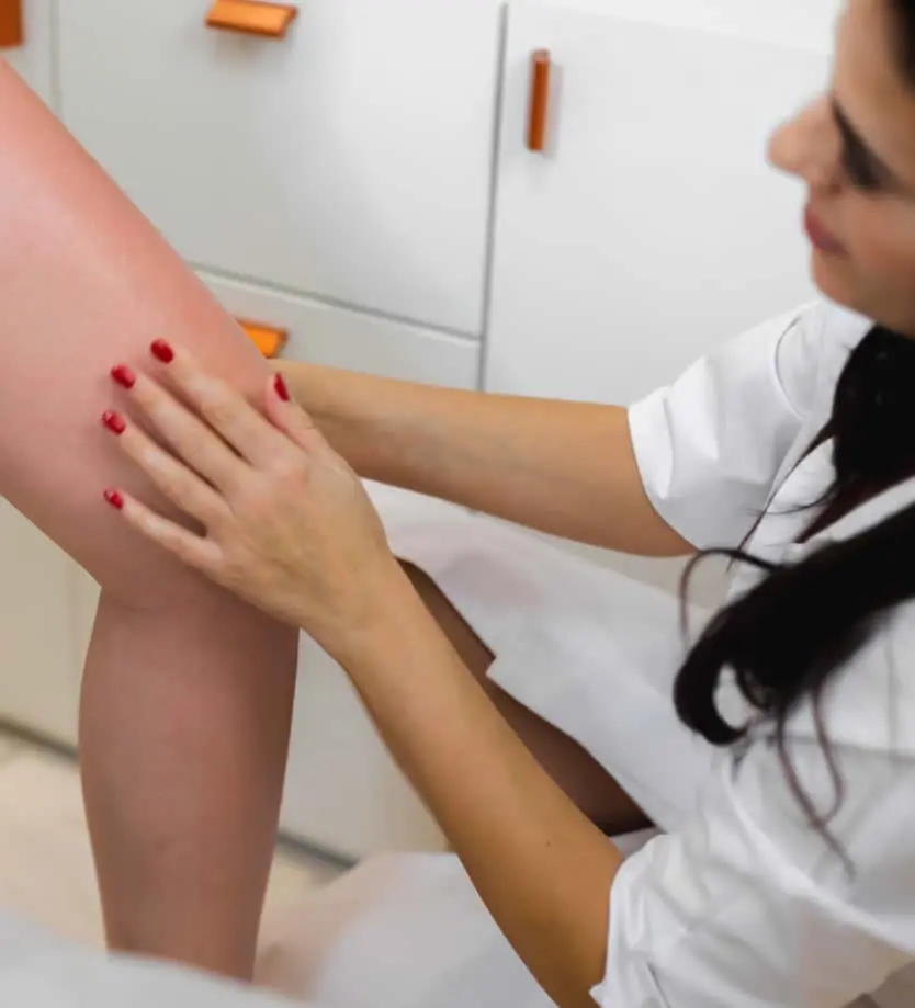 happy mature woman dermatologist checking leg